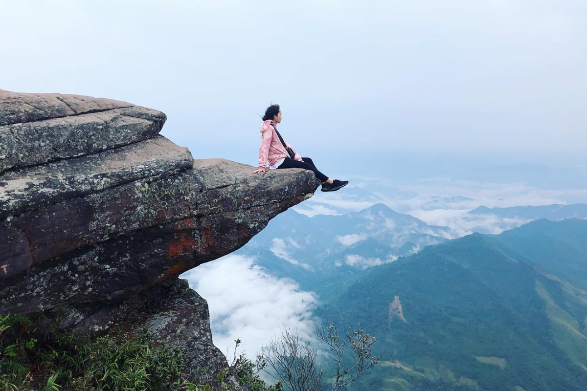 View from the top of Pha Luong Peak showing green mountains and blue skies across the Vietnam-Laos border